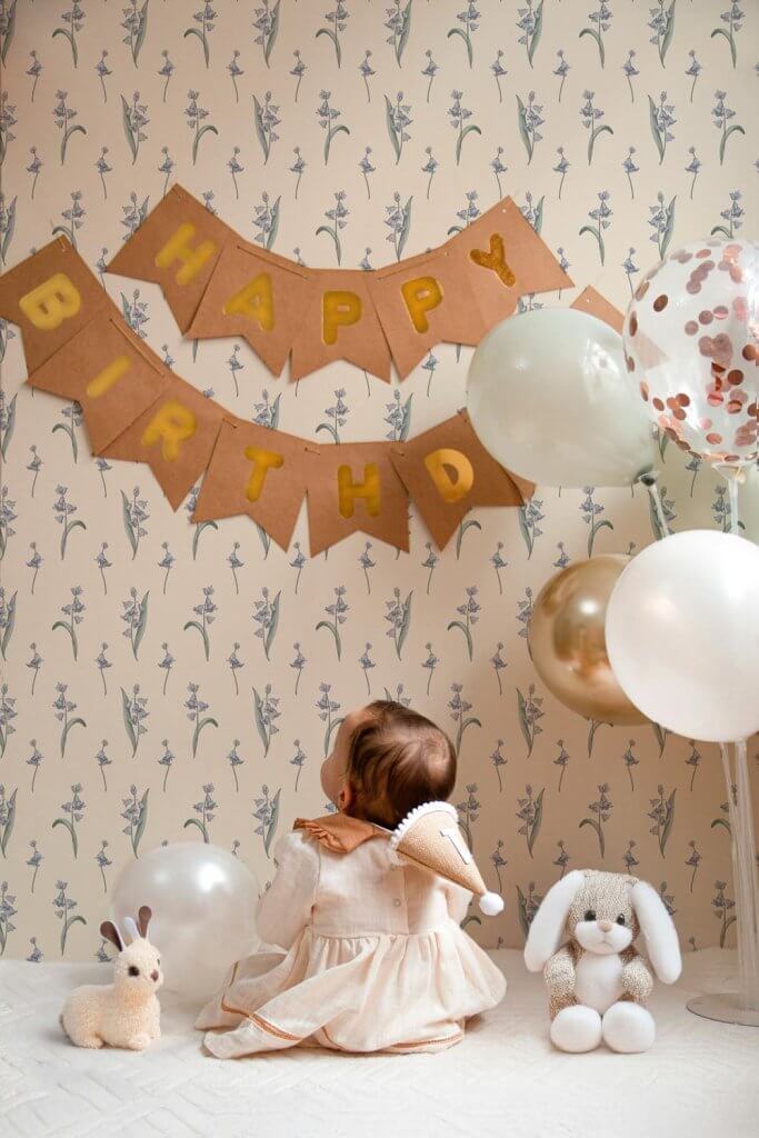 Delicate bluebells motif on walls in front of a baby celebrating her anniversary