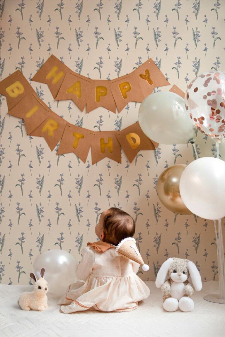 Delicate bluebells motif on walls in front of a baby celebrating her anniversary